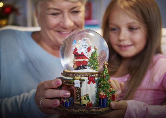 Musical snow globe glowing on a decorated Christmas table