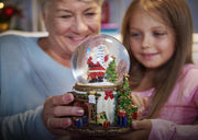 Musical snow globe glowing on a decorated Christmas table