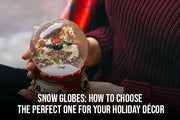 Musical snow globe with a holiday village scene on a wooden table